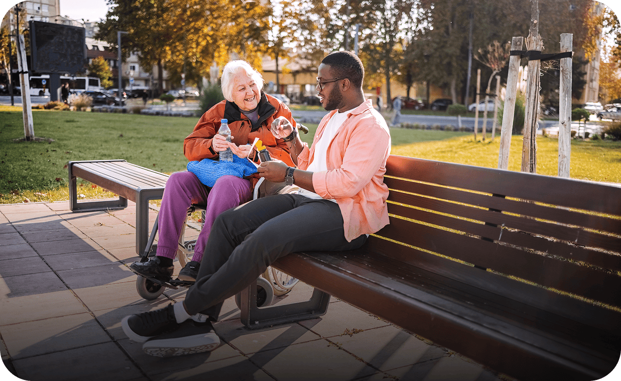 Elderly woman and man chatting on bench.