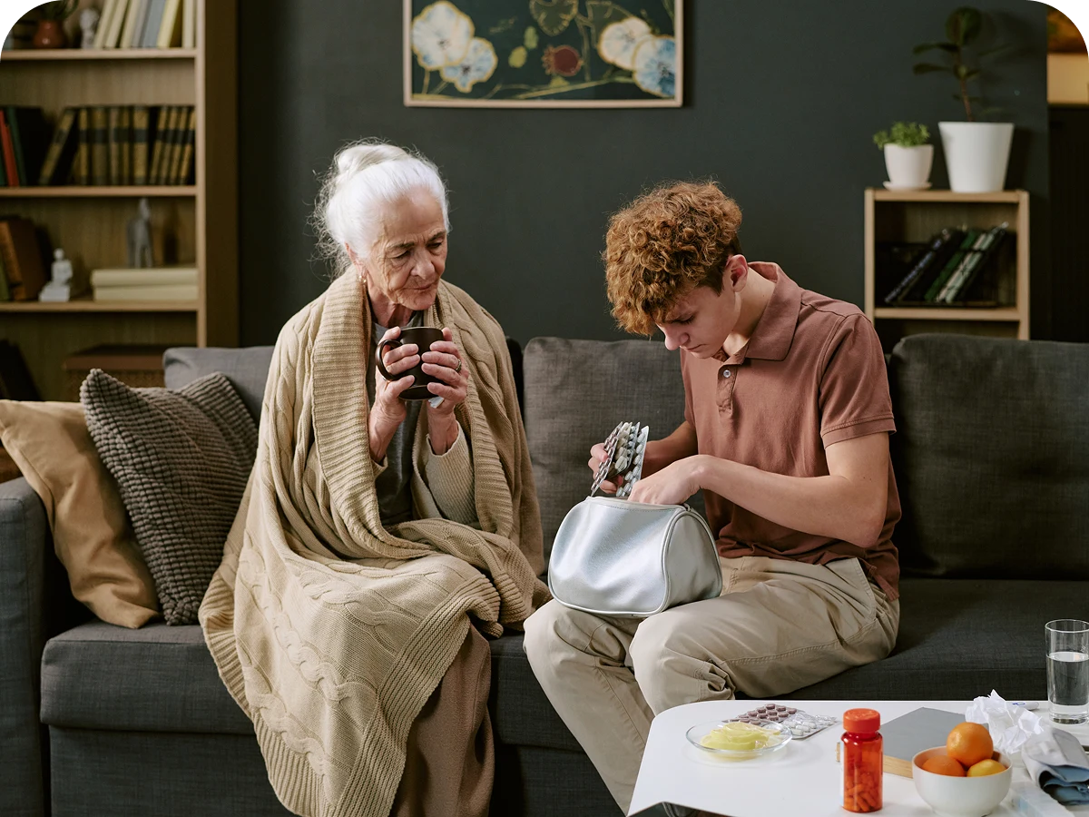 Elderly woman and young man on sofa.