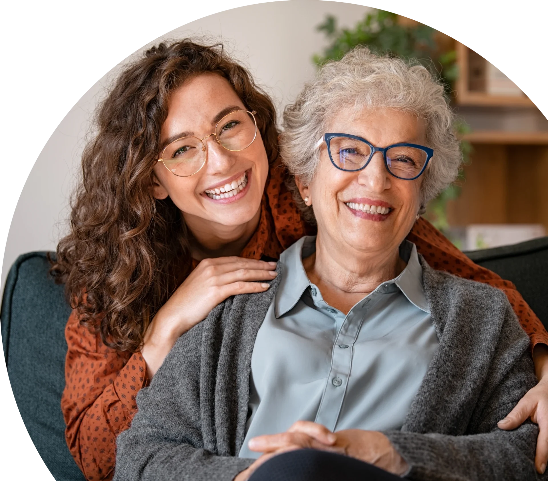 Smiling women sitting together on couch.