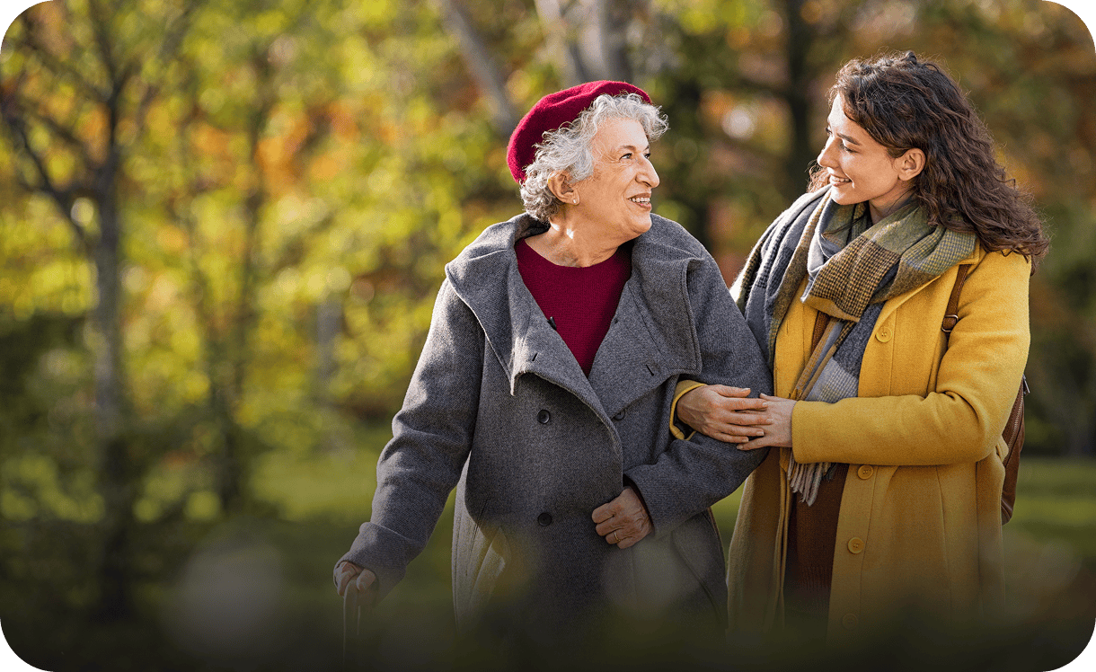 Elderly woman and younger woman walking together.